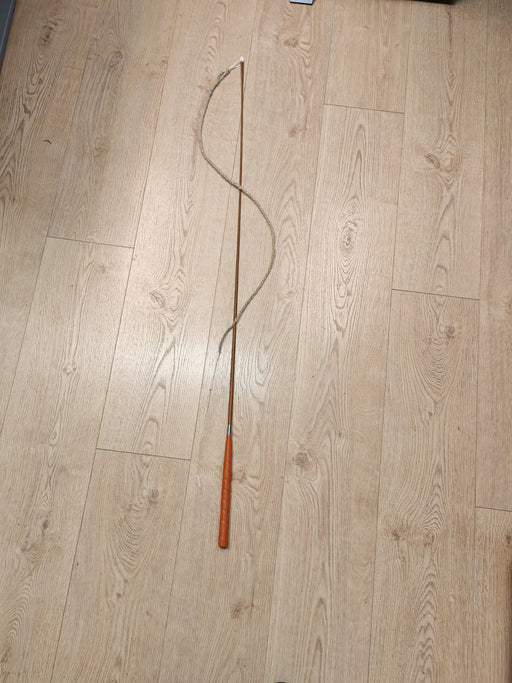 Goaßl Schnalzerpeitsche mit Strick, vollständig auf einem Holzboden ausgelegt
